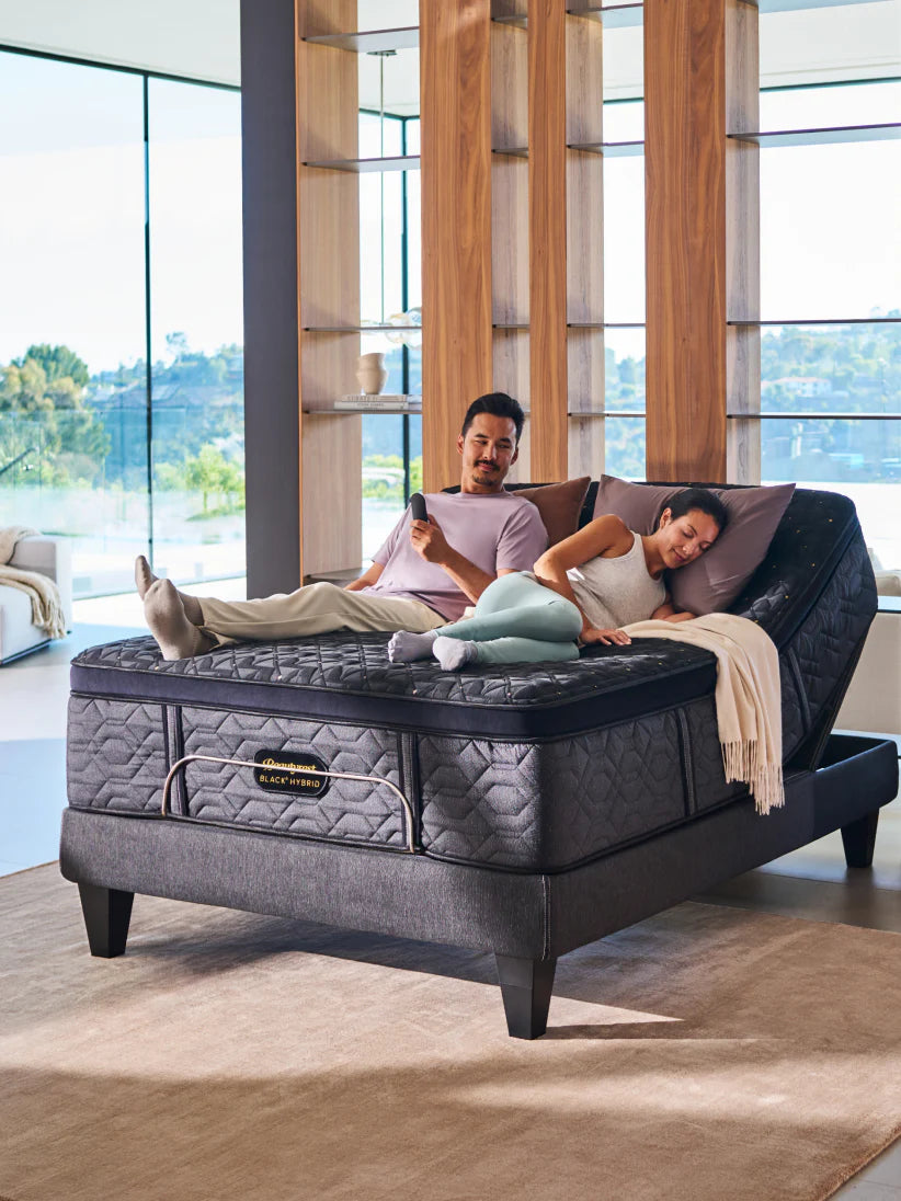 Man and woman laying on an adjustable bed frame in a bright modern room