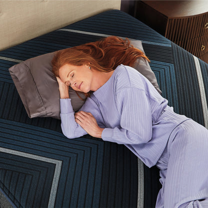 Woman laying on a Beautyrest World Class Hybrid mattress on her right side asleep with her head on a pillow