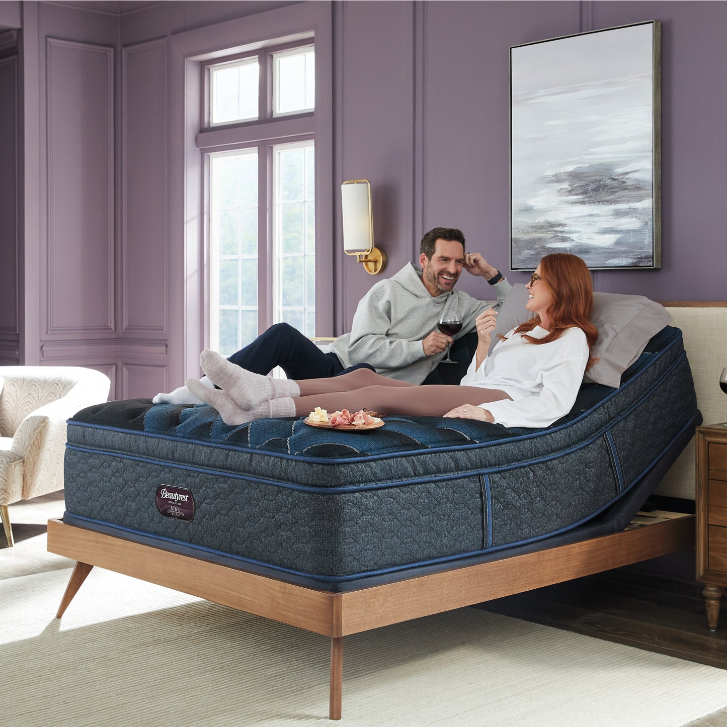 Man and woman laying in an upright position on a Beautyrest World Class Plush Pillowtop mattress elevated on an adjustable base