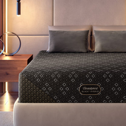 Beautyrest Black Hybid XCS mattress on a cream bed frame with gray bedding in a bedroom setting