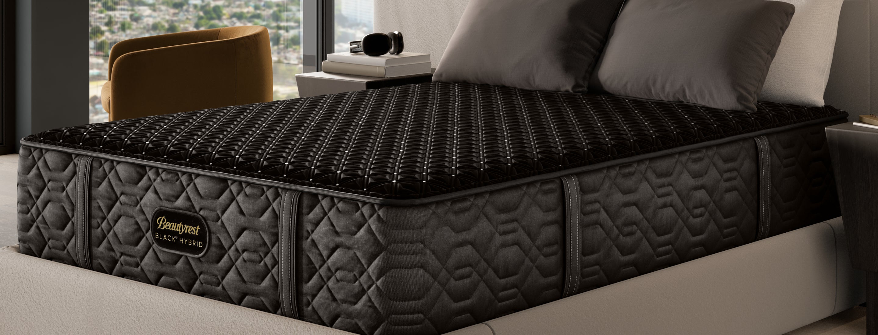 Side view of the Beautyrest black hybrid mattress sitting on a cream bed frame with pillows sitting on top of it.