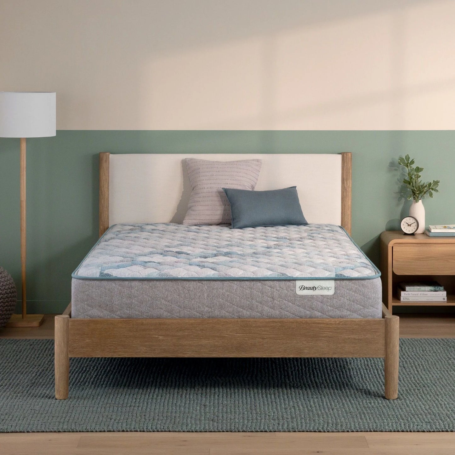 Beautysleep by Beautyrest mattress in a brown bedframe in a room setting with a lamp and nightstand.
